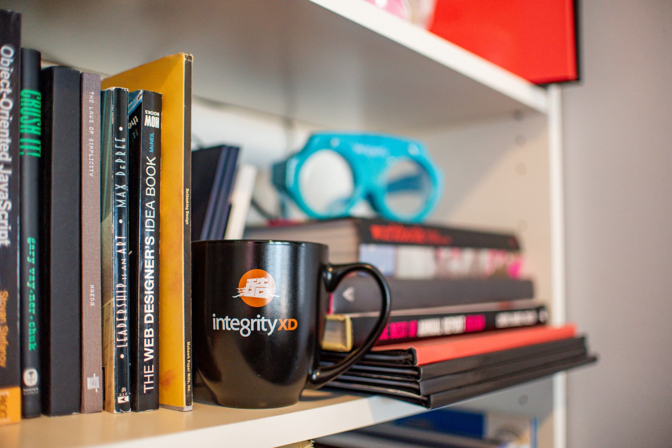 Bookshelf in St Louis Integrity office with branded coffee mug